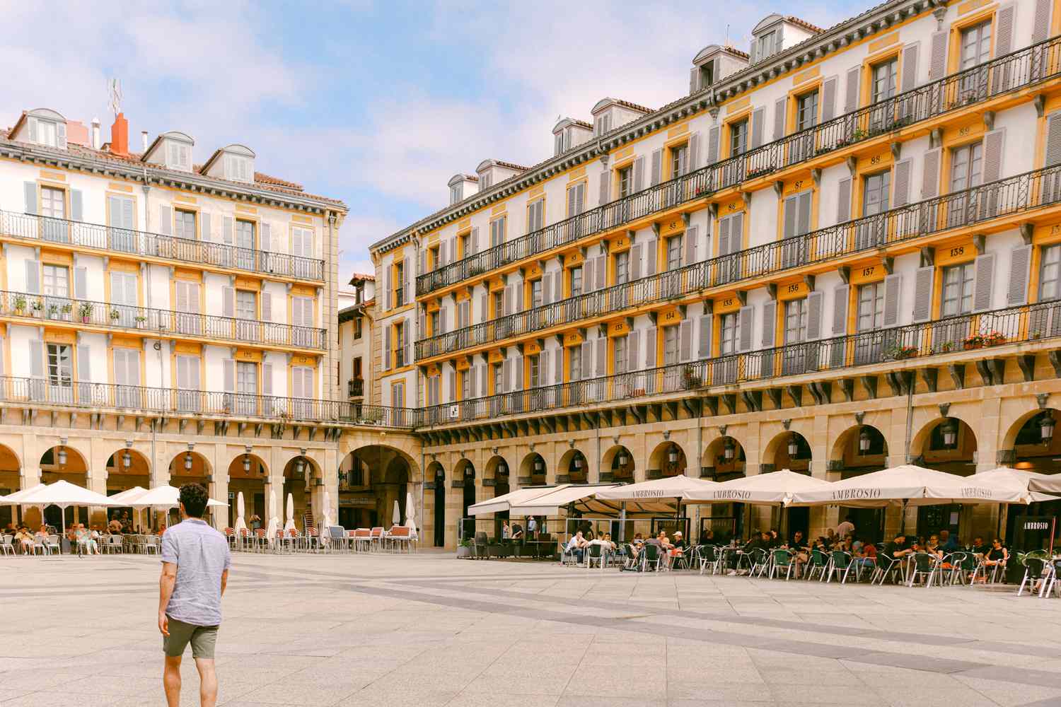 Expats enjoying outdoor dining and social connectivity in a vibrant Spanish plaza.