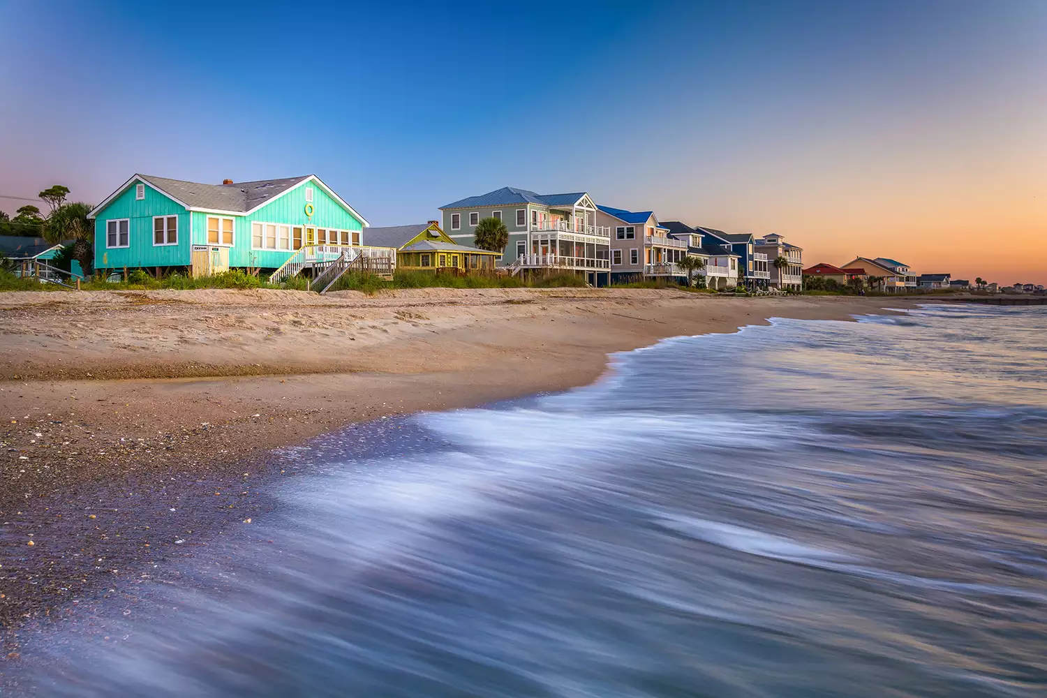 Quiet sunrise over the Atlantic Ocean with beachfront homes at Edisto Beach.
