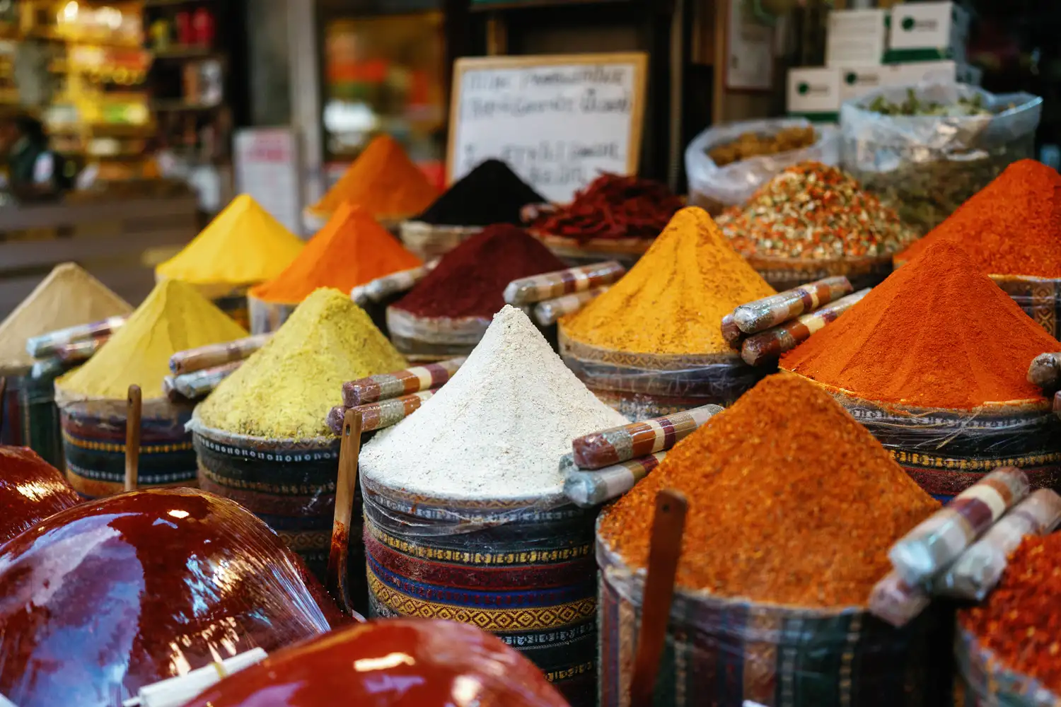 Assorted vibrant spices and powders arranged in conical piles at an Istanbul market.