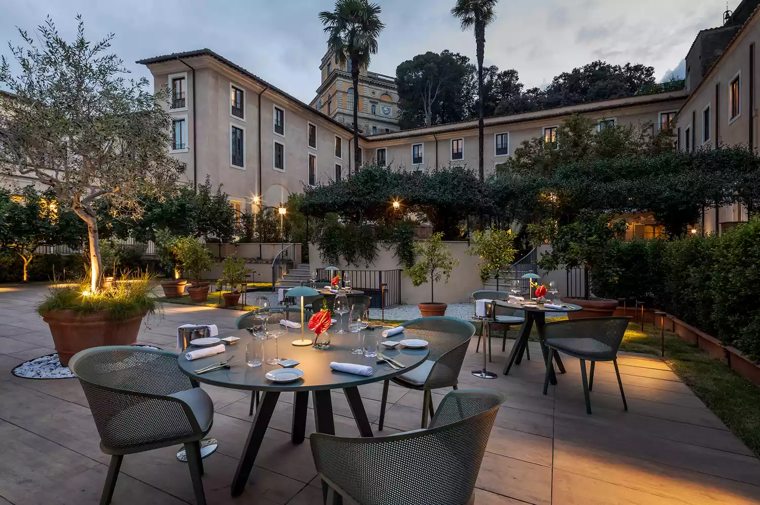 Tables set for outdoor dining in the historic courtyard of the hotel restaurant.