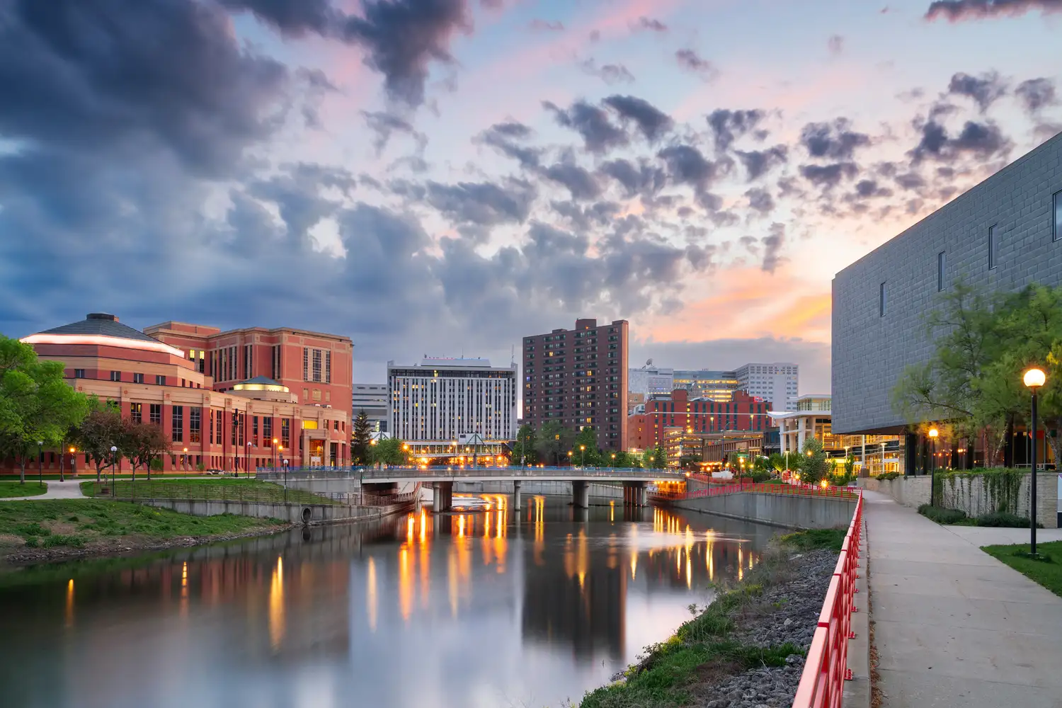 Urban buildings of Rochester, Minnesota along a river during sunset.