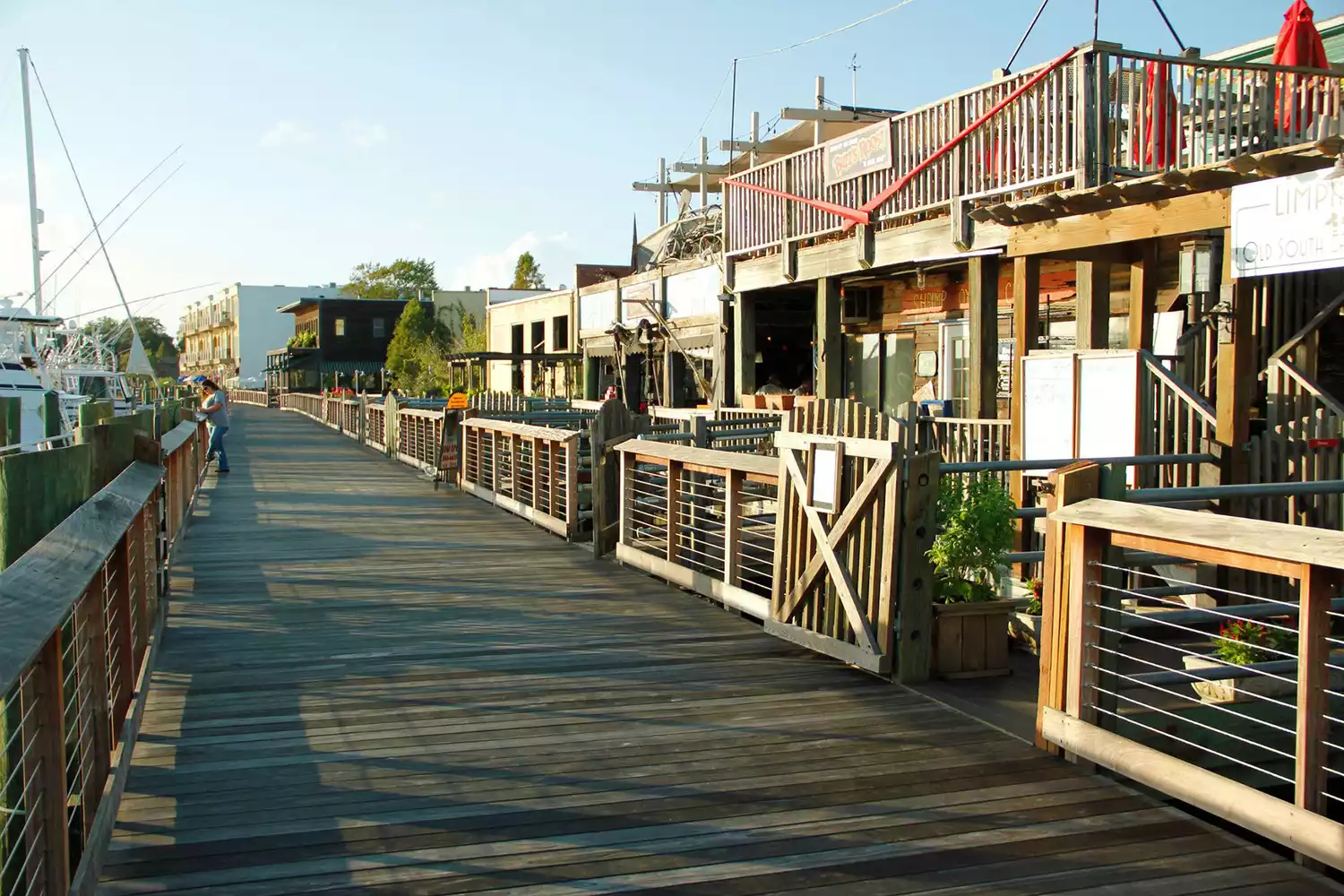 Wooden boardwalk along the Georgetown Harborwalk at sunset.