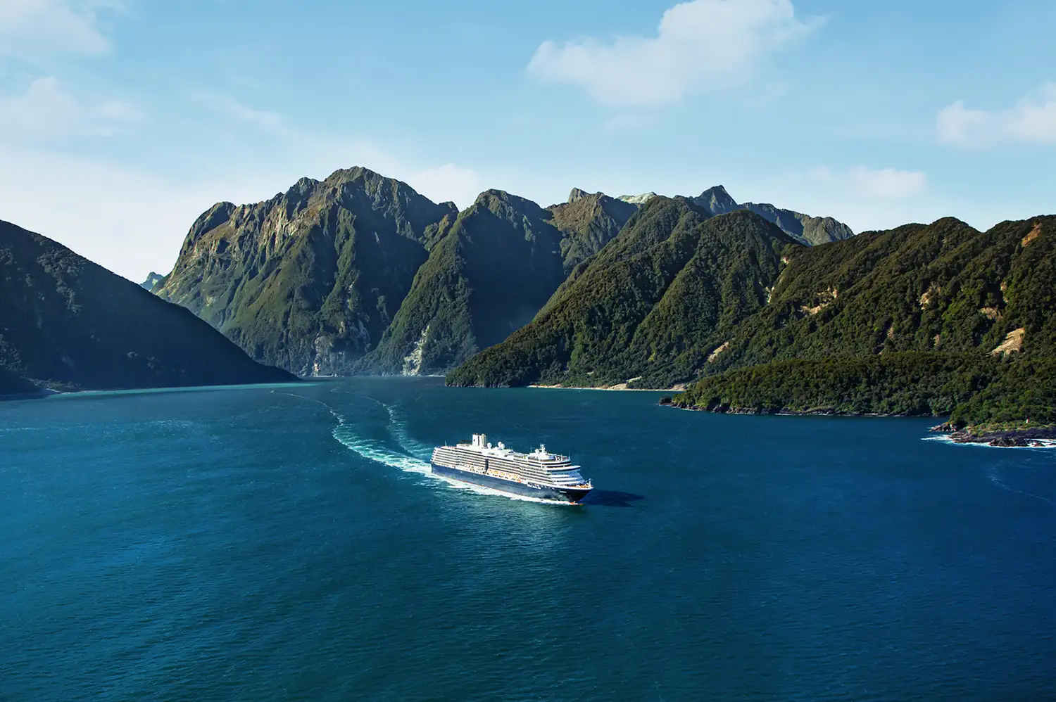 The MS Westerdam ship sailing through the majestic fjords of New Zealand's Milford Sound.