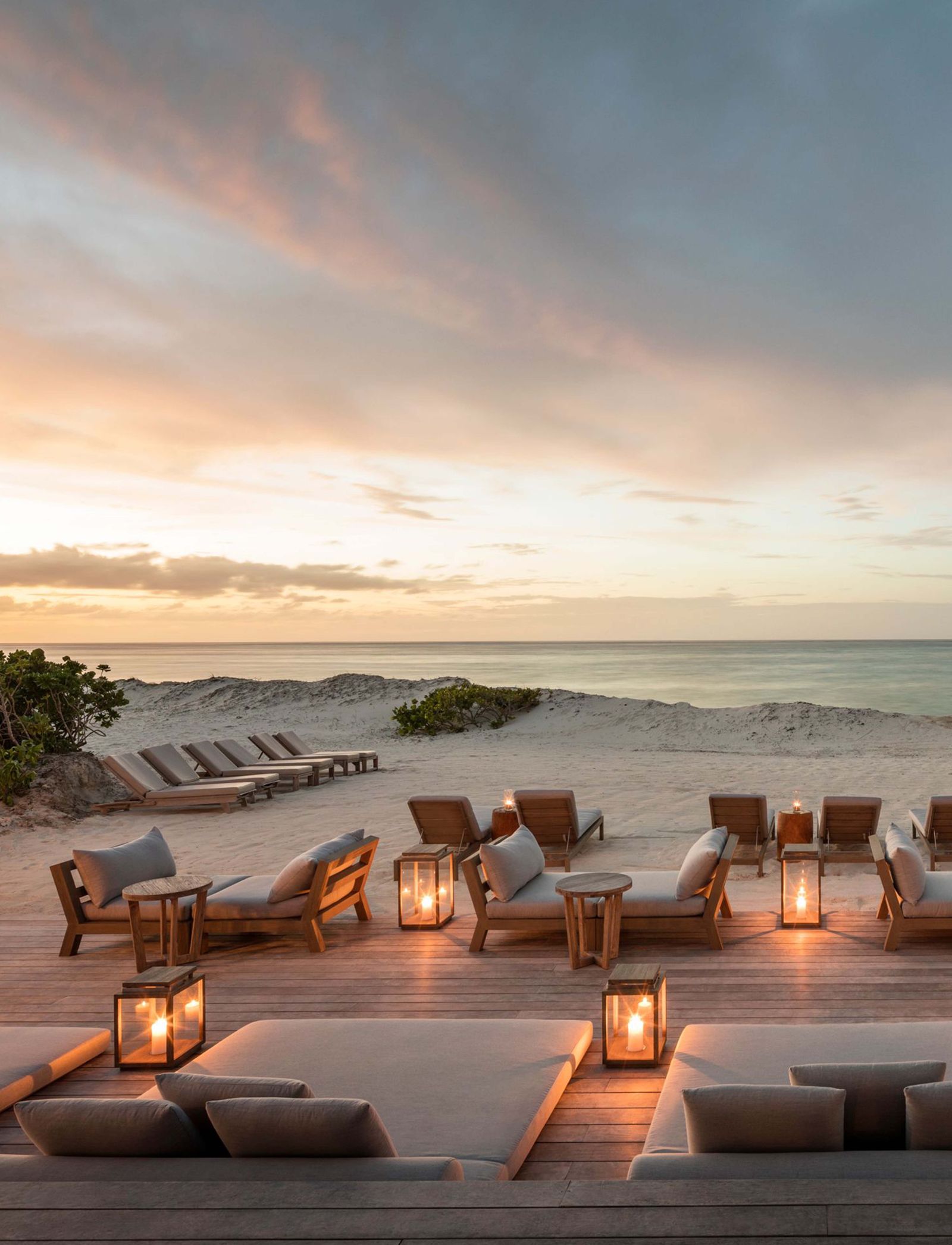 A minimalist luxury lounge area with a view of the clear blue sky and horizon.