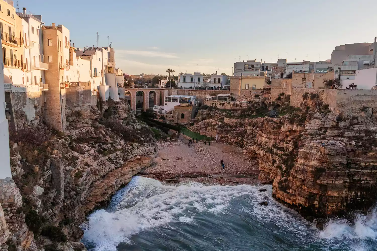 A scenic view of a rocky Mediterranean beach with turquoise water in the Puglia region.