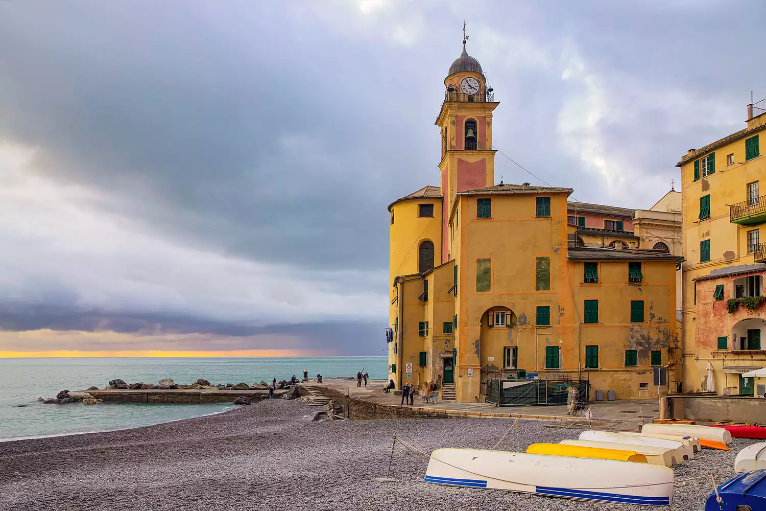 Vibrant multi-colored houses stacked along the harbor in the fishing village of Camogli, Liguria.