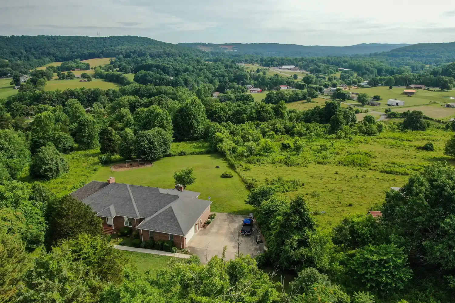 An aerial perspective of rolling hills and lush green forests in the Tennessee highlands.