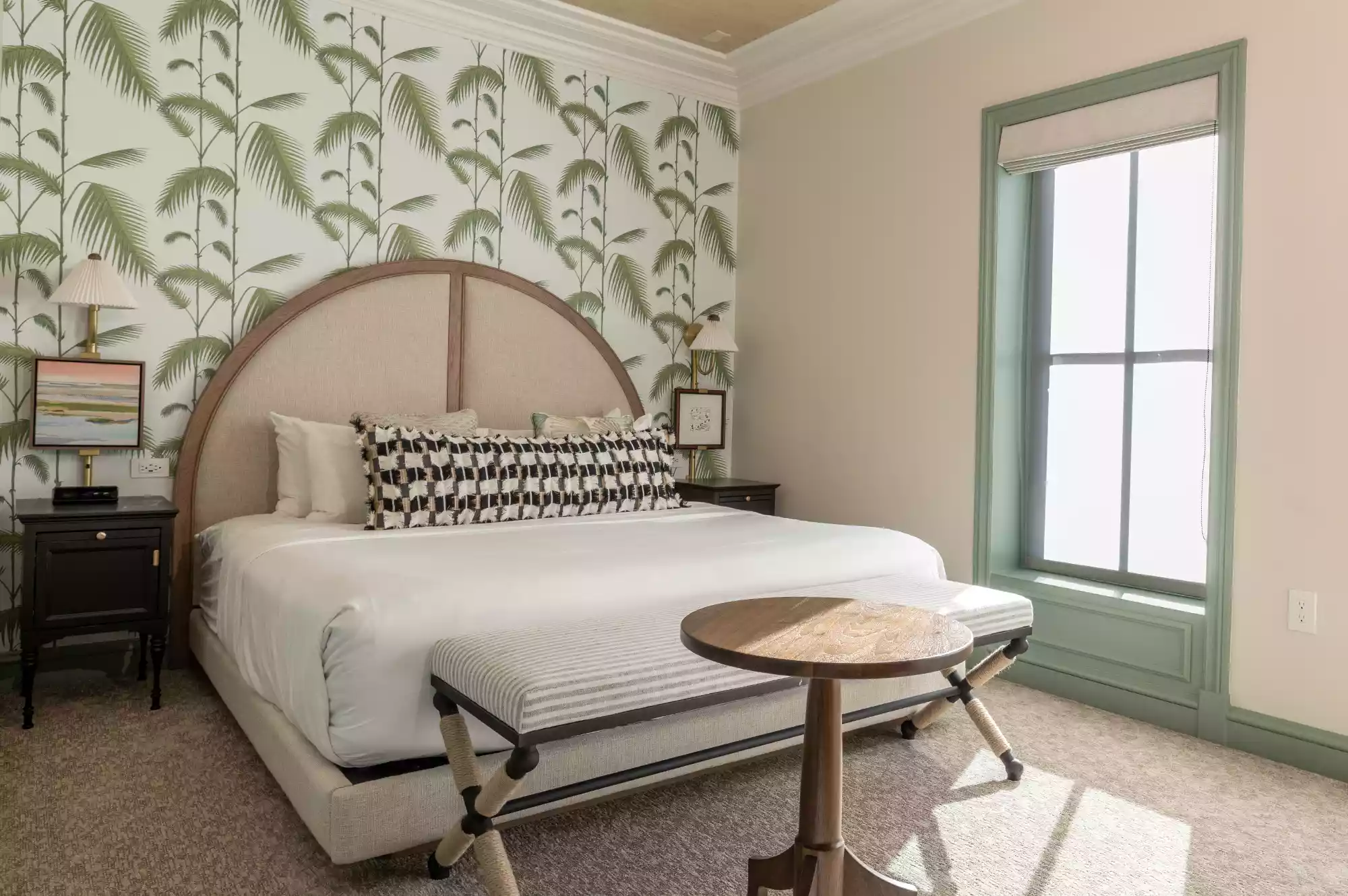Boutique king guest room with custom palmetto wallpaper and retro-inspired furnishings.
