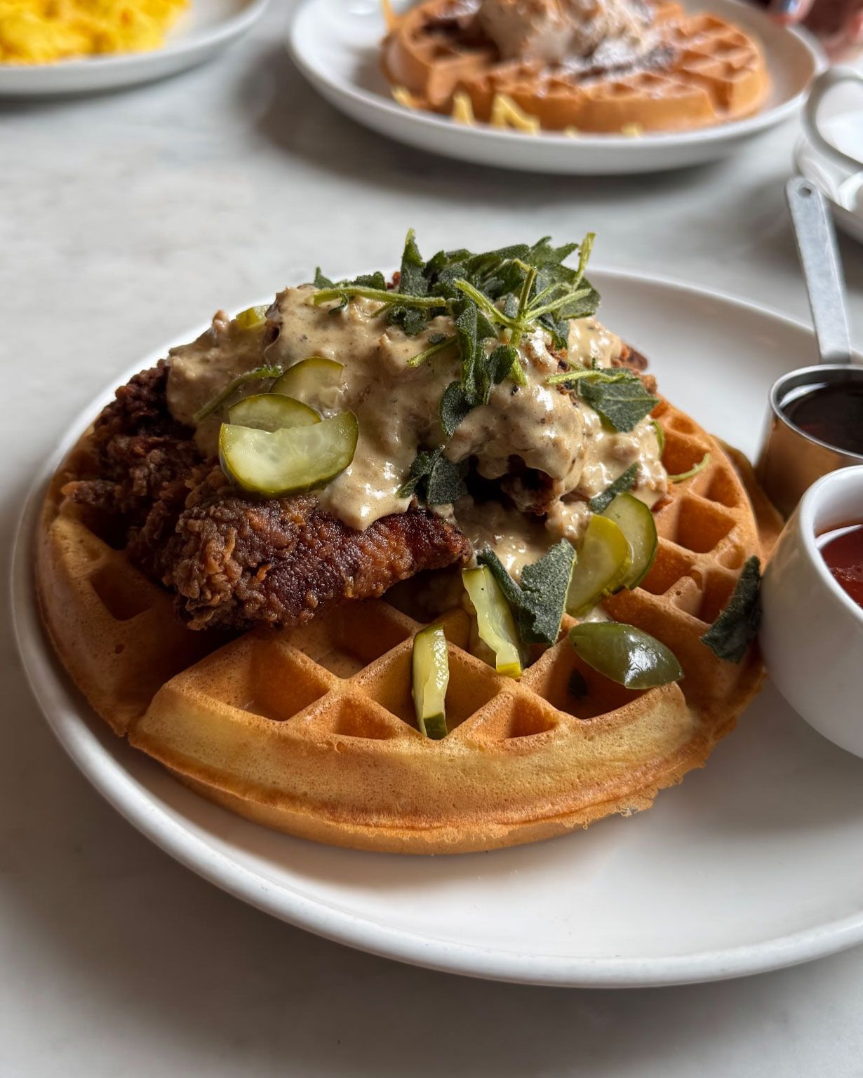 A beautifully plated breakfast featuring waffles and coffee on a white tablecloth.