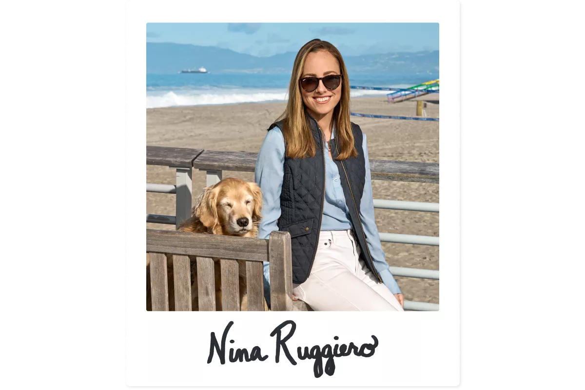 The editor posing at the beach with her dog, symbolizing pet-friendly and personal travel expert tips.