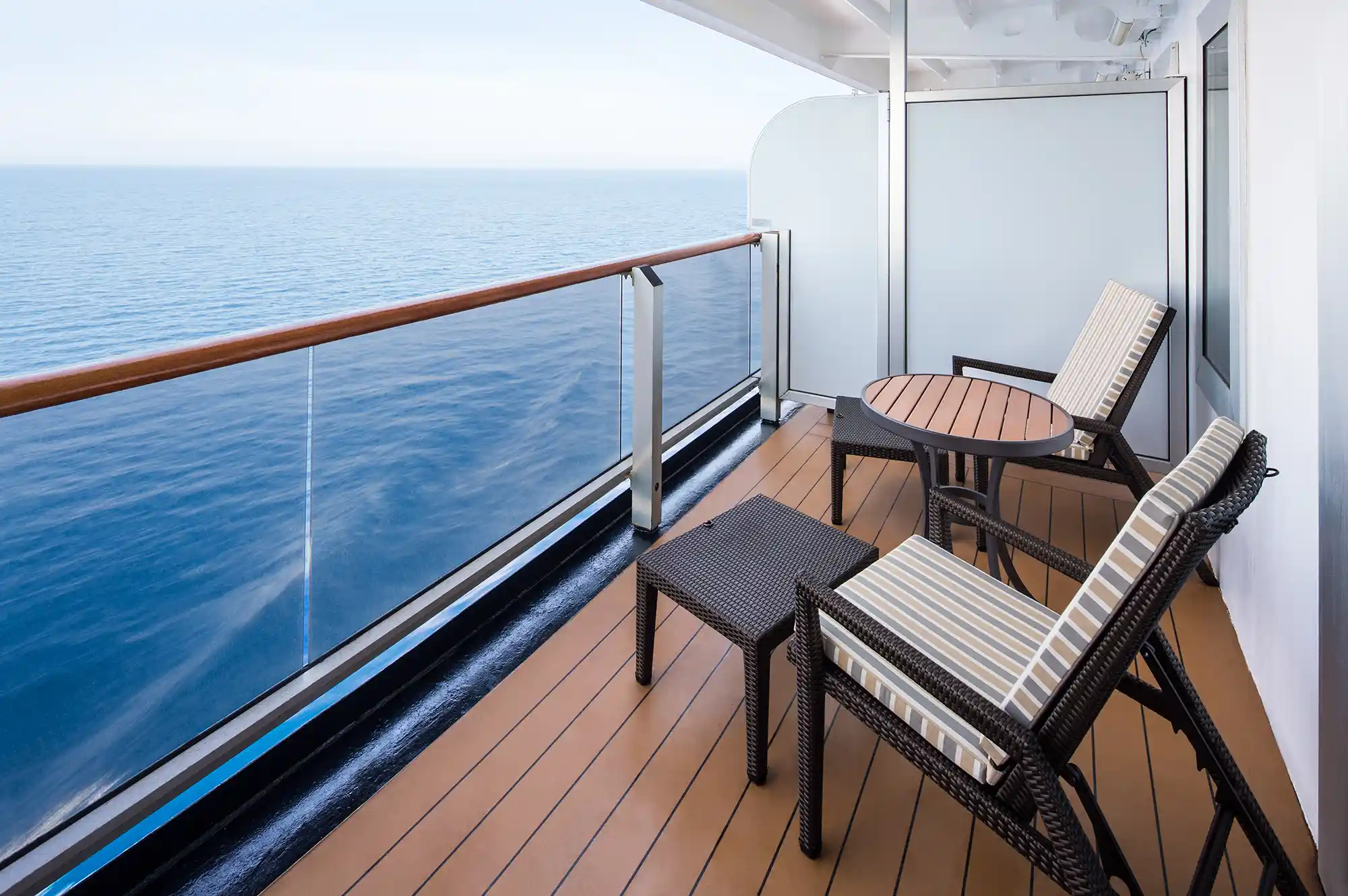 Perspective from a private cabin balcony overlooking the ship's side and the sea.