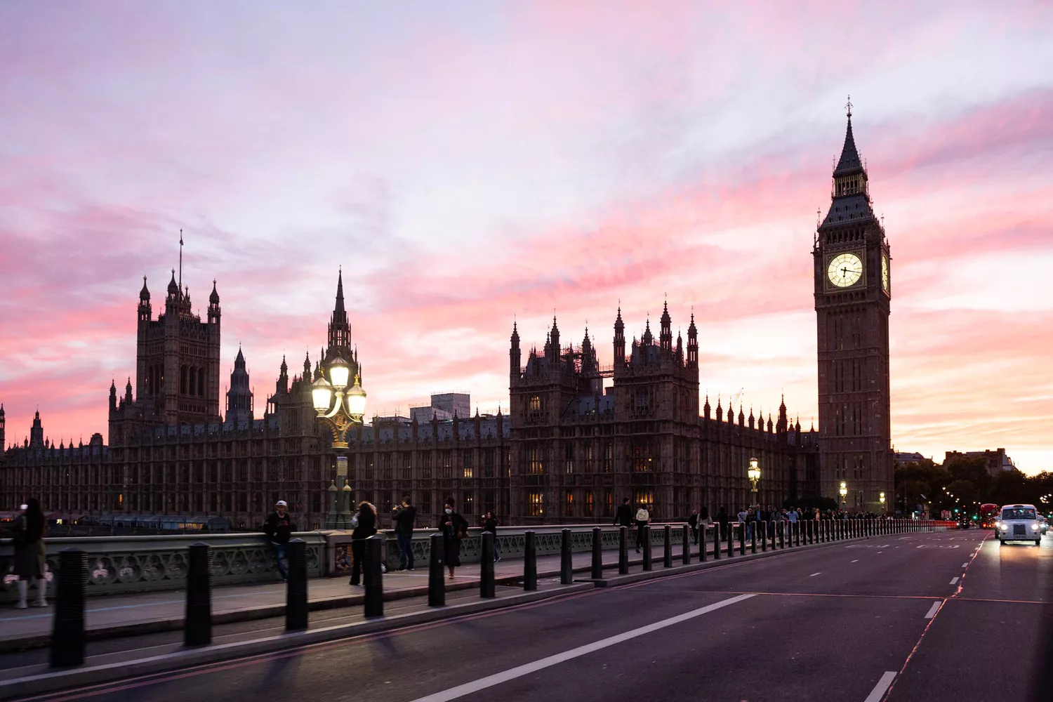 The Houses of Parliament and Big Ben in London at sunset with a warm sky.