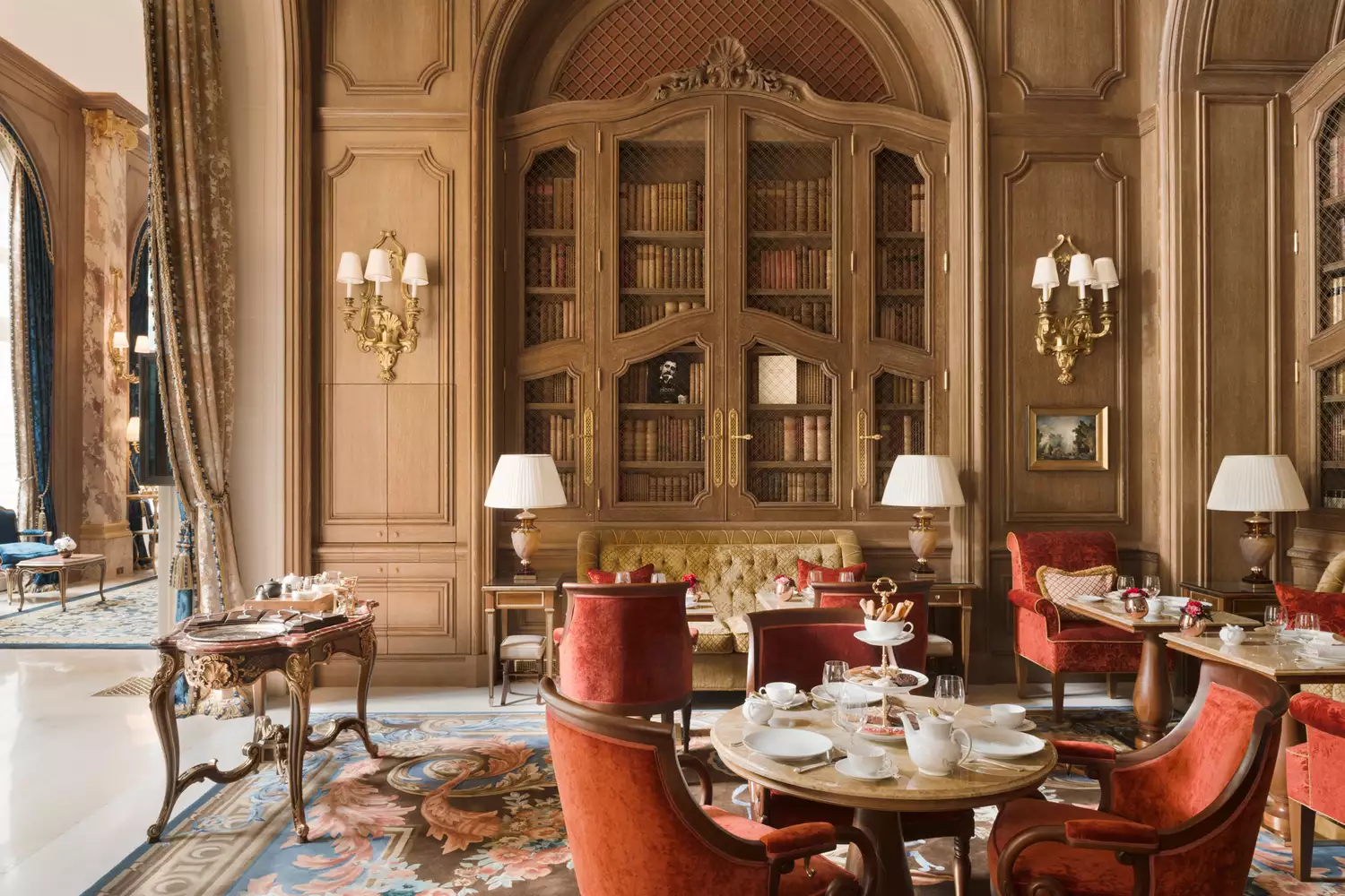 The opulent, gold-trimmed dining room of the Ritz Paris during a fine dining service.