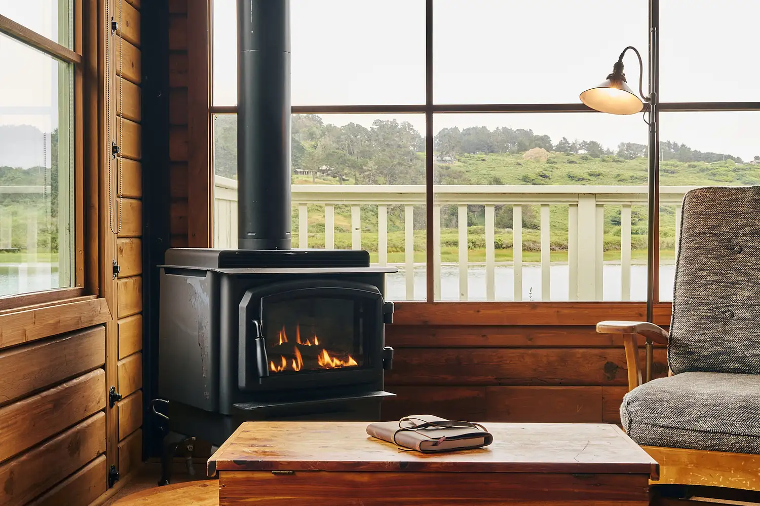 A view from inside the suite showing a fireplace and a direct view of a private deck surrounded by trees.