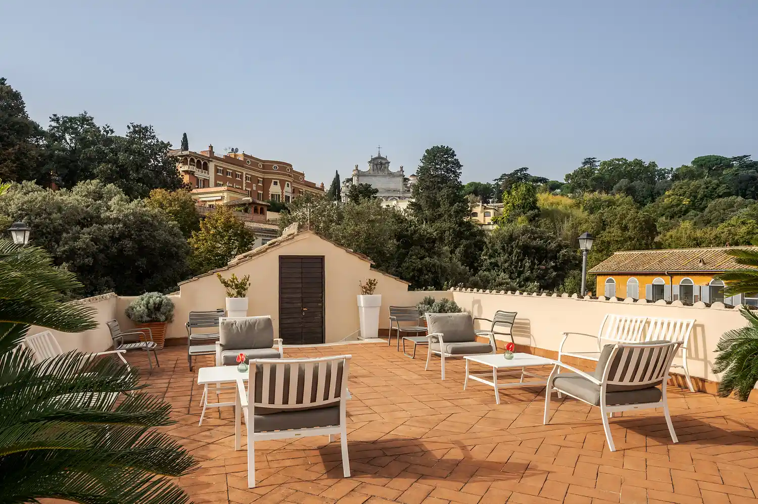 A wide view of Rome's terracotta roofs and monuments seen from the hotel's rooftop terrace.