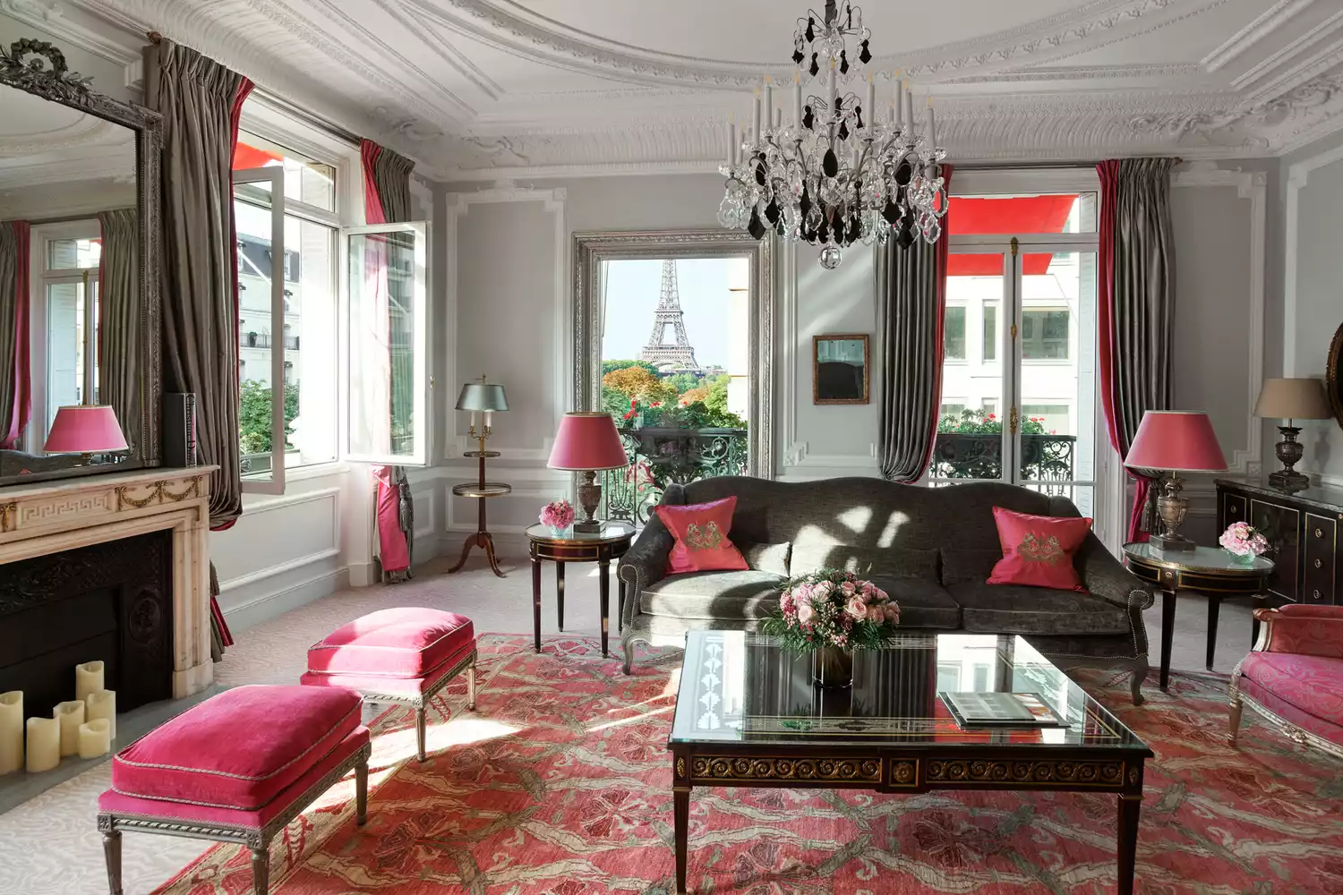 A luxury Parisian suite balcony with red geraniums overlooking the Eiffel Tower at Plaza Athénée.