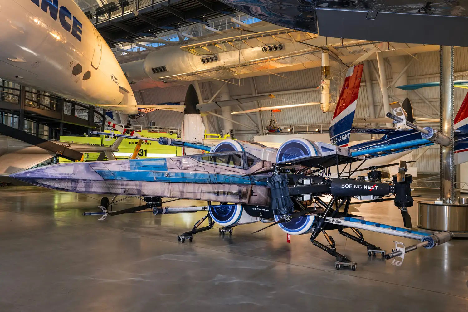 A full-scale replica of an X-Wing starfighter displayed among historic aircraft at the Steven F. Udvar-Hazy Center.