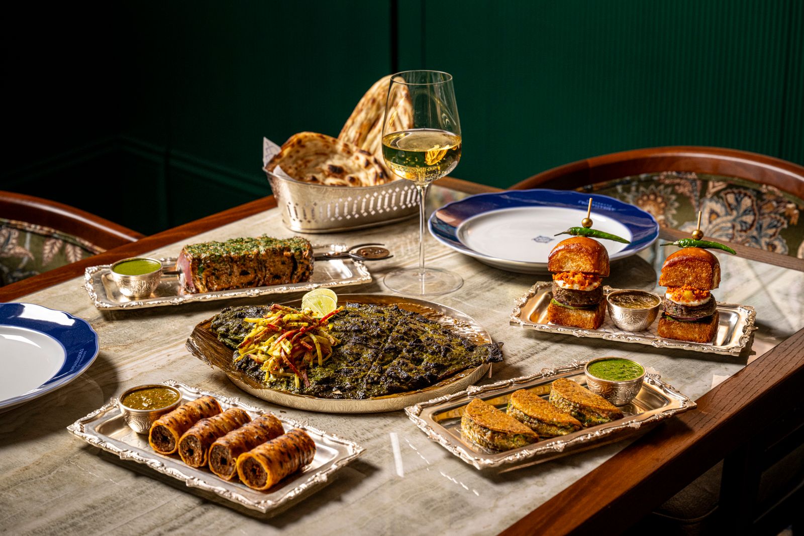 A gourmet meal presentation featuring multiple small bowls of vegetarian Indian curry and sides.