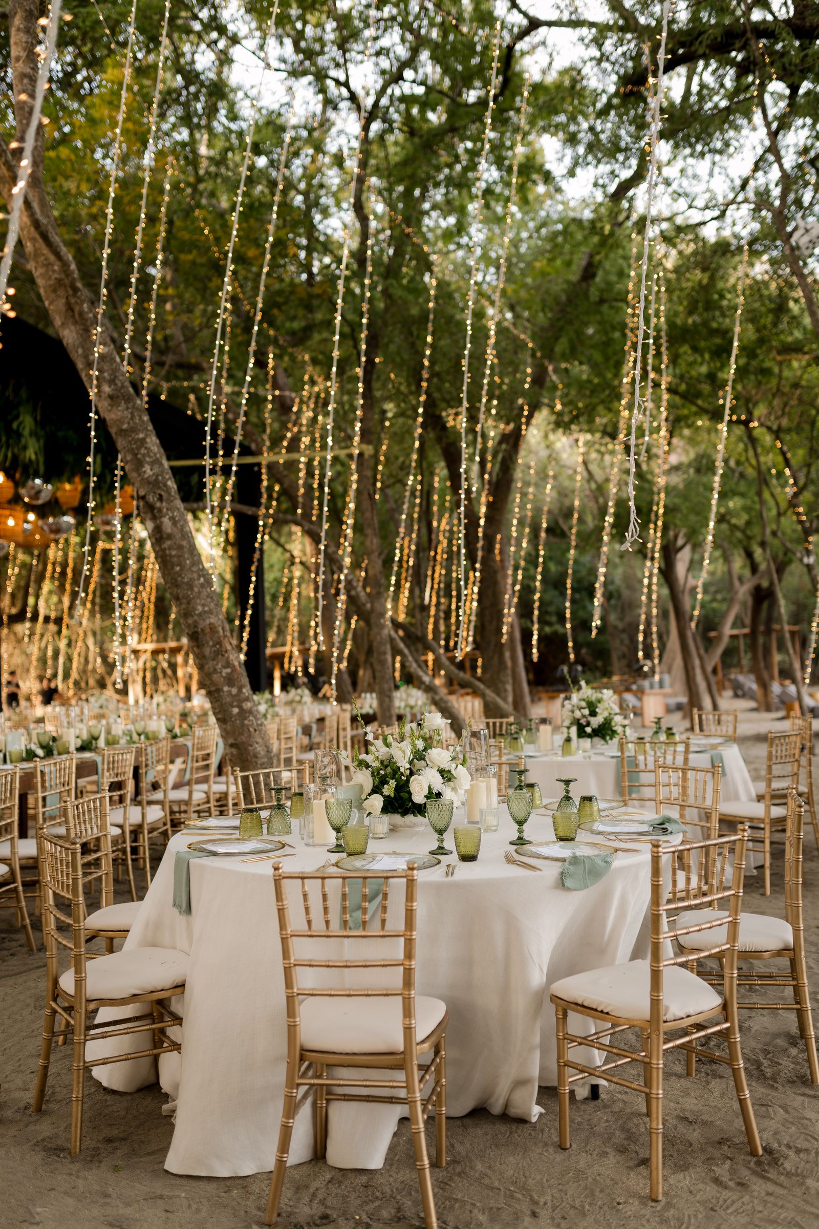 An elegantly set banquet hall with dining tables and chairs for a wedding reception.